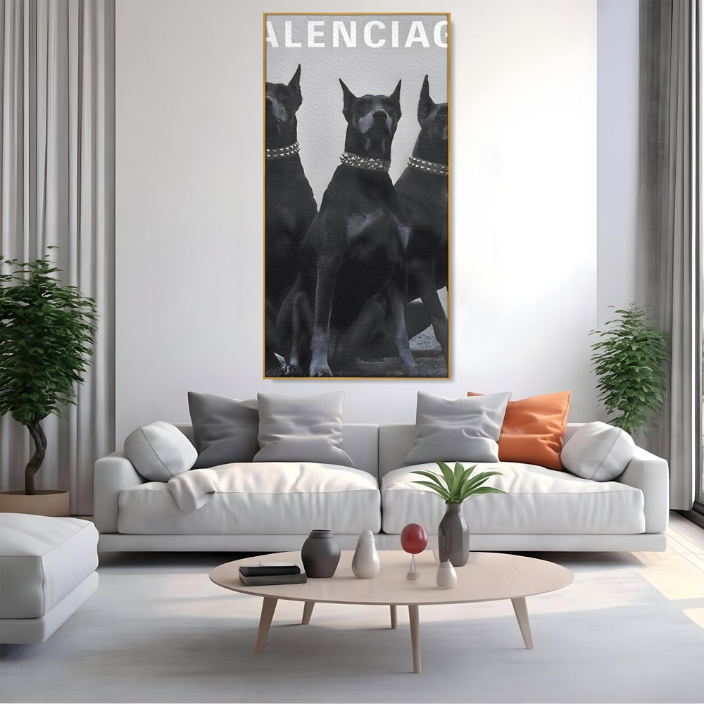 Tablou canvas cu tablou canvas cu trei dobermani, in rama de aluminiu auriu, pe perete intr-un living